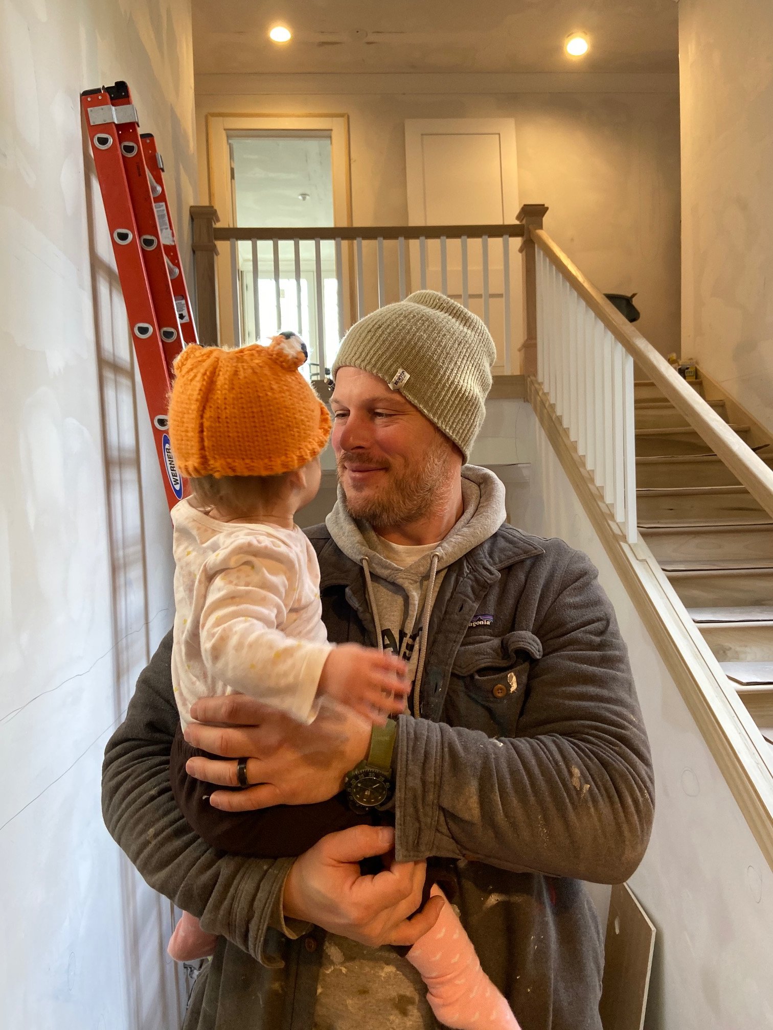 Carson Little holding his daughter Piper on a job site